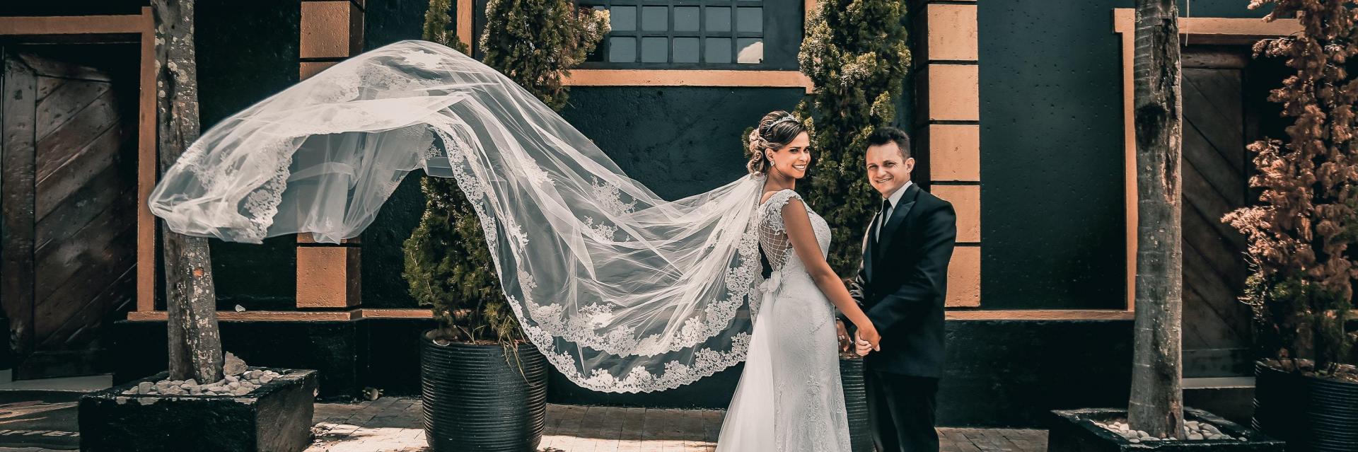 groom and bride in long flowing lace veil